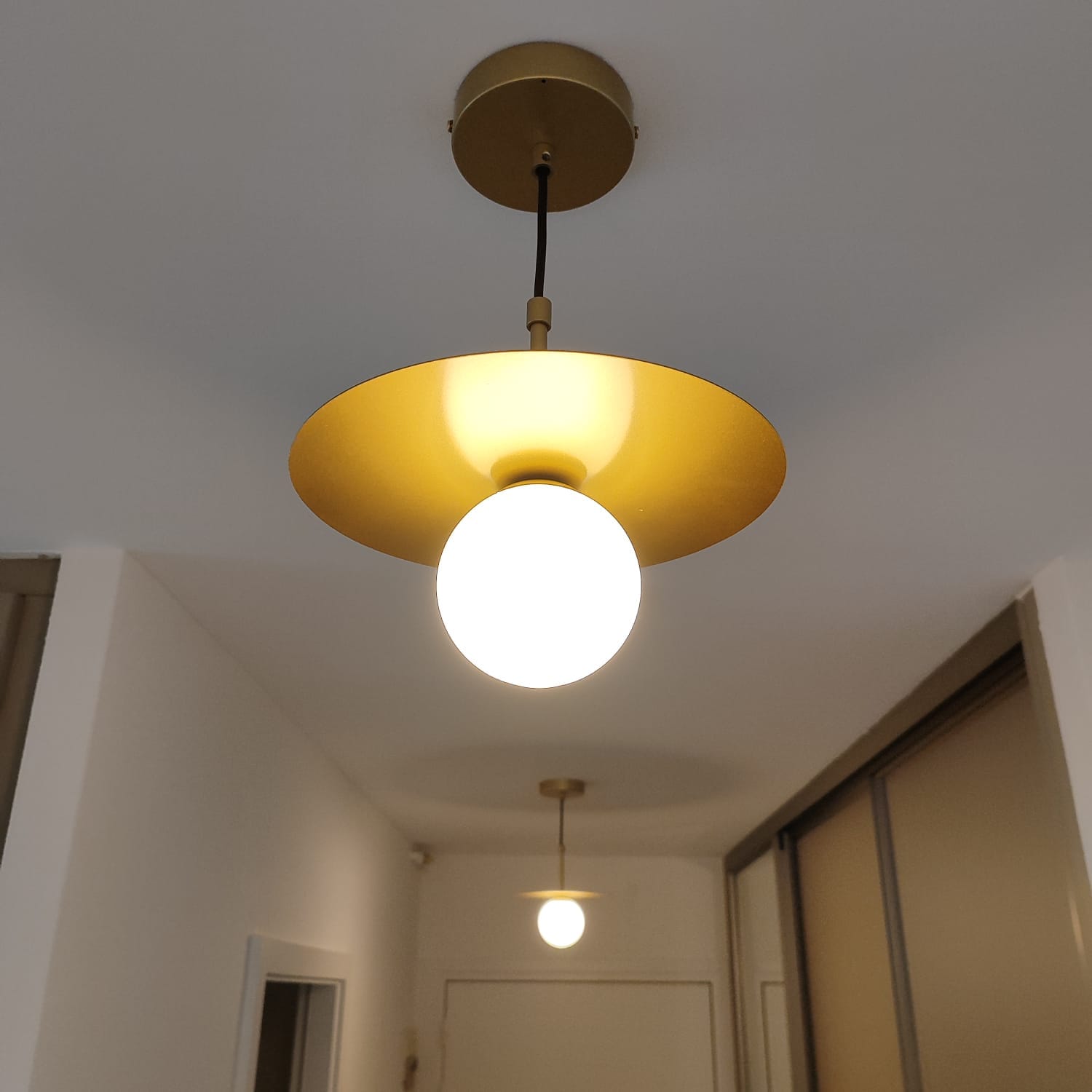 Flur mit goldenen Messing-Pendelleuchten und Opalglaskugeln, Wohnung in Saint-Louis
