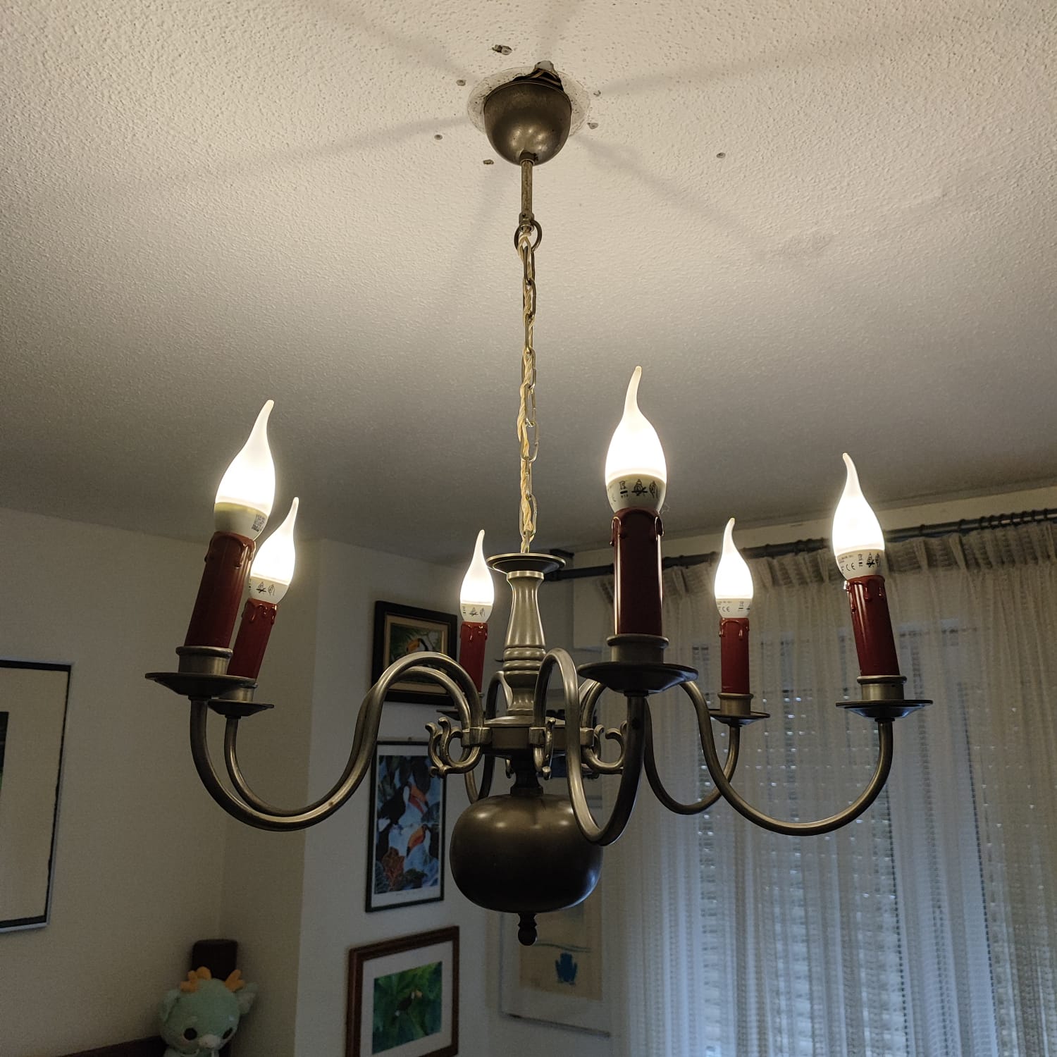 Lustre à cinq flammes LED en forme de bougie raccordé au plafond d'un séjour