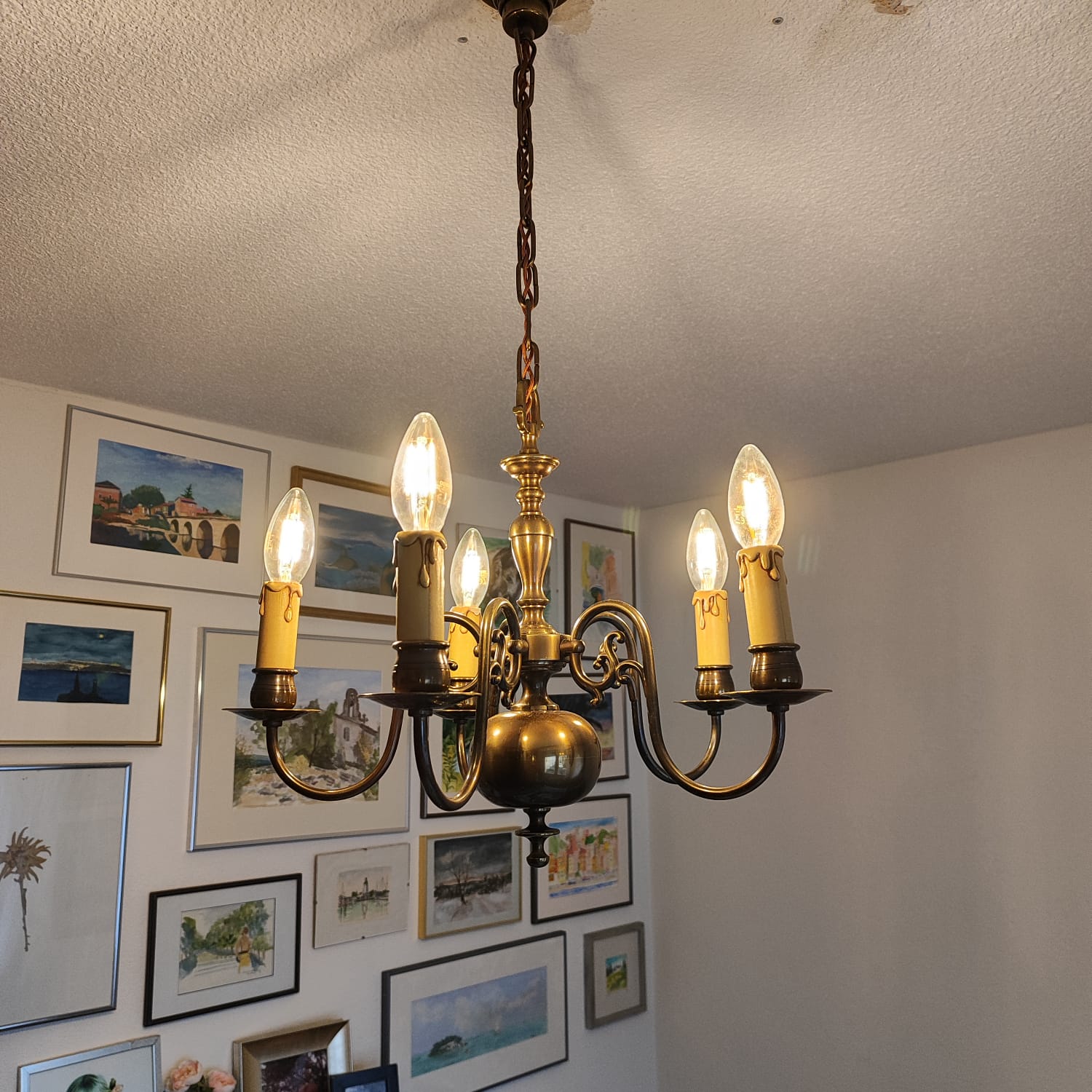 Lustre en bronze à cinq lumières avec ampoules bougies posé au plafond d'un salon