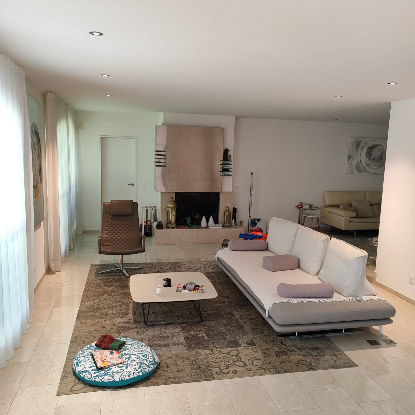 Wohnbereich mit Kamin und per Hausautomation gesteuerter LED-Einbaubeleuchtung, Villa in der Schweiz
