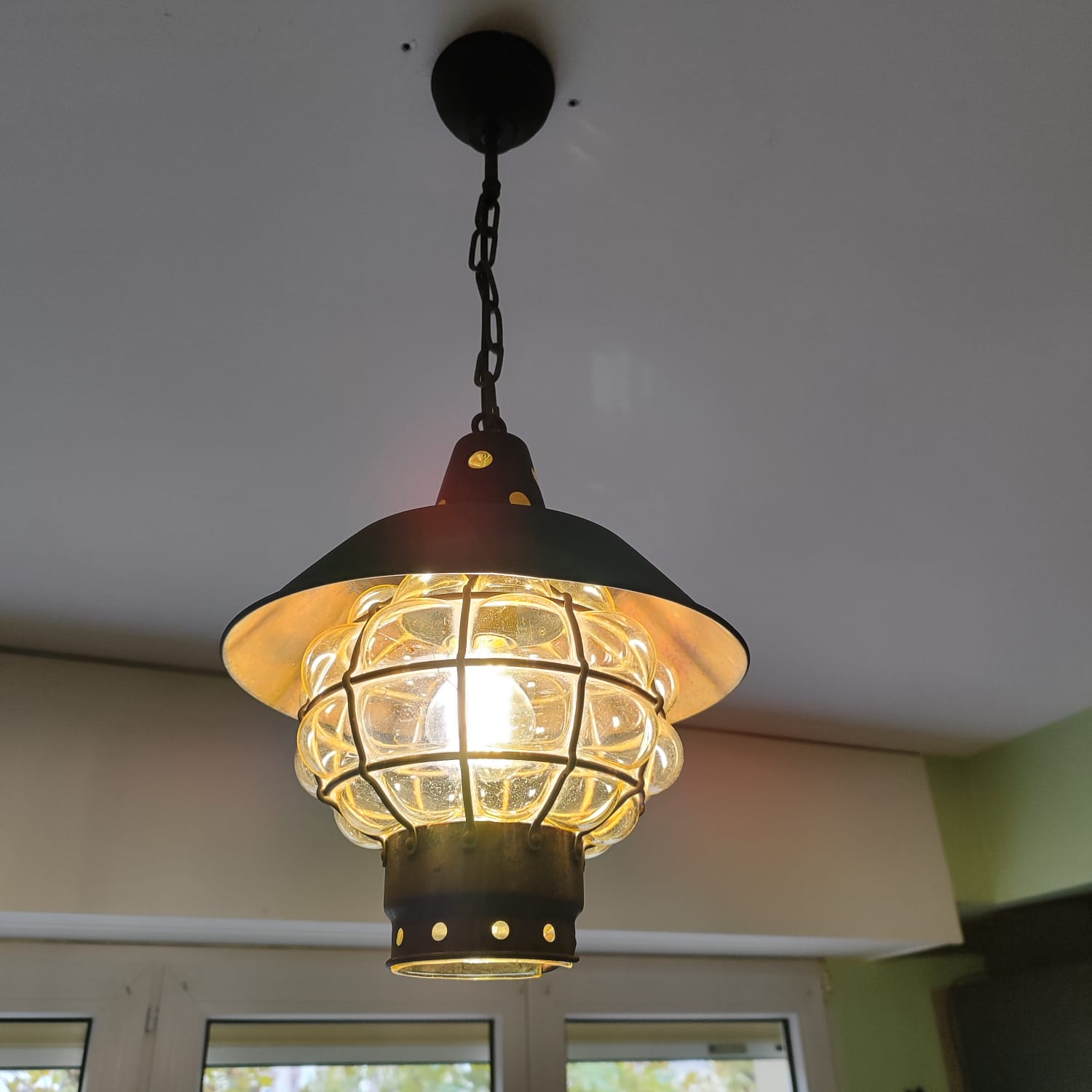 Suspension lanterne noire à cage de verre suspendue au plafond d'une cuisine